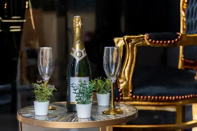 a bottle of champagne and two glasses on a table at La Suite Tentation in Cannes