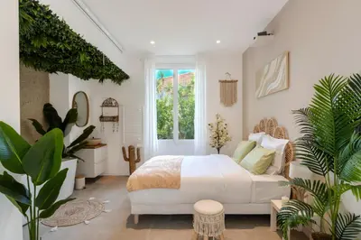 a bedroom with a white bed and some plants at La Suite Jardin Secret in Cannes