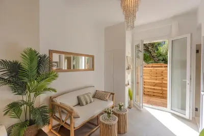 a living room with a couch and a plant at La Suite Jardin Secret in Cannes