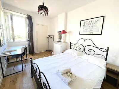 a bedroom with a large white bed and a desk at Sunny 1 Bedroom Rue Commandant André in Cannes