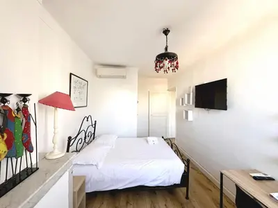 a bedroom with a bed and a desk and a television at Sunny 1 Bedroom Rue Commandant André in Cannes