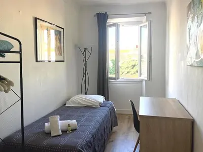 a bedroom with a bed and a desk and a window at Sunny 1 Bedroom Rue Commandant André in Cannes