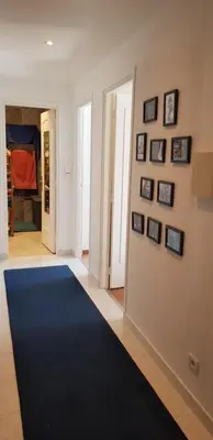 a hallway with a blue rug on a wall with pictures at Sunshine in Cannes in Cannes