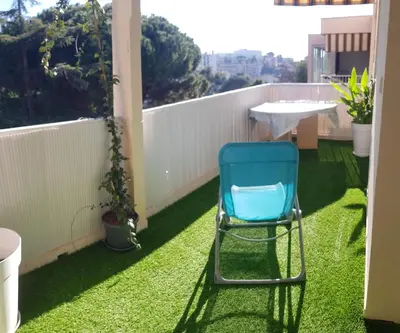 a blue chair sitting on the grass on a balcony at Sunshine in Cannes in Cannes