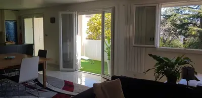 a living room with a table and a sliding glass door at Sunshine in Cannes in Cannes