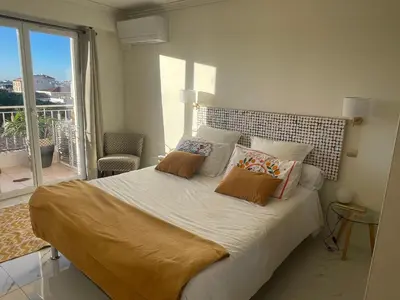 a bedroom with a bed with pillows and a balcony at appartement centre ville cannes vue mer in Cannes