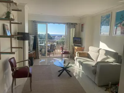a living room with a couch and a glass table at appartement centre ville cannes vue mer in Cannes