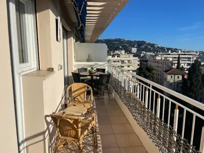 a balcony with chairs and a table on a balcony at appartement centre ville cannes vue mer in Cannes