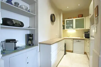 a kitchen with white cabinets and a counter top at Sea View Apartment in Cannes