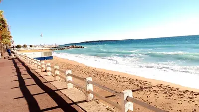 a fence on a beach with the ocean at Sea View Apartment in Cannes