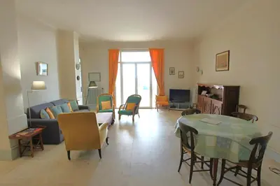 a living room with a couch and a table and chairs at Sea View Apartment in Cannes