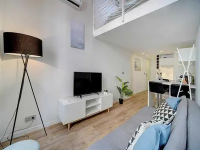 a living room with a couch and a tv in it at Bright duplex - Cannes Centre - Mobility lease in Cannes