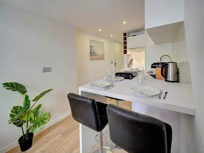 a kitchen with two bar stools and a counter top at Bright duplex - Cannes Centre - Mobility lease in Cannes