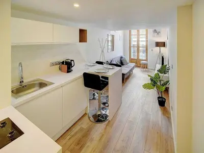 a kitchen and living room with a sink and a table at Bright duplex - Cannes Centre - Mobility lease in Cannes