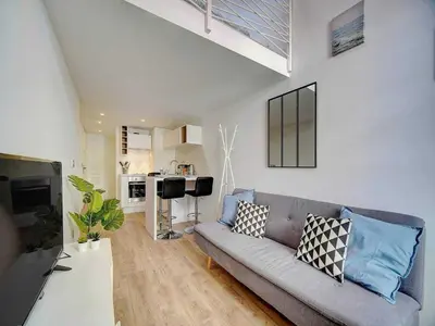 a living room with a couch and a kitchen at Bright duplex - Cannes Centre - Mobility lease in Cannes