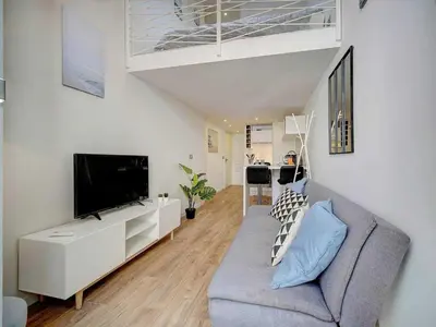 a living room with a couch and a flat screen tv at Bright duplex - Cannes Centre - Mobility lease in Cannes