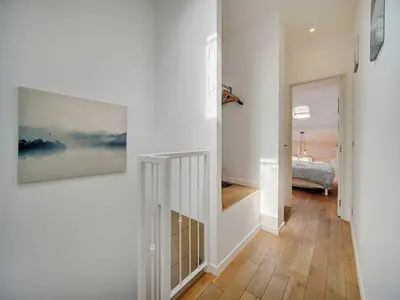 a hallway with a staircase and a painting on a wall at Bright duplex - Cannes Centre - Mobility lease in Cannes