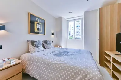 a small bedroom with a bed and a television at Cosy apartment with parking - Cannes - Mobility Lease in Cannes