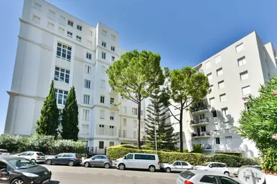 a parking lot with cars parked in front of buildings at Cosy apartment with parking - Cannes - Mobility Lease in Cannes