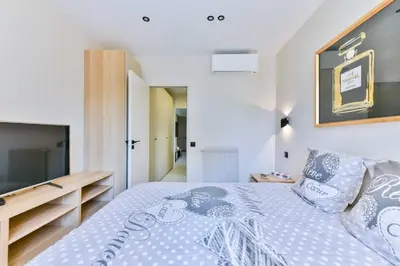 a bedroom with a large bed and a television at Cosy apartment with parking - Cannes - Mobility Lease in Cannes
