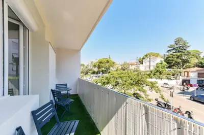 a balcony with two chairs and a view of a street at Cosy apartment with parking - Cannes - Mobility Lease in Cannes