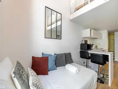 a living room with a white couch and a table at Bright duplex-Cannes Centre -Mobility lease in Cannes