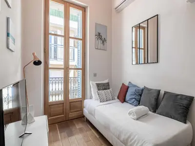 a living room with a white couch and a window at Bright duplex-Cannes Centre -Mobility lease in Cannes