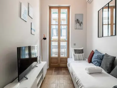 a living room with a couch and a tv at Bright duplex-Cannes Centre -Mobility lease in Cannes