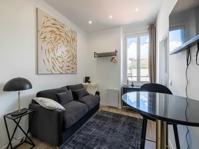 a living room with a couch and a glass table at Sublime studio - Cannes center - Mobility lease in Cannes