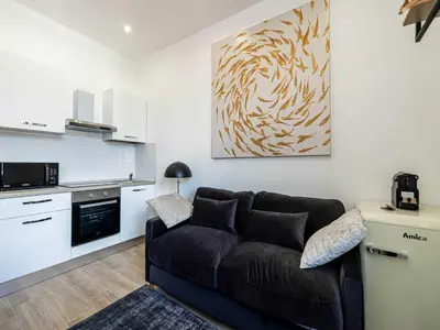 a living room with a couch and a kitchen at Sublime studio - Cannes center - Mobility lease in Cannes