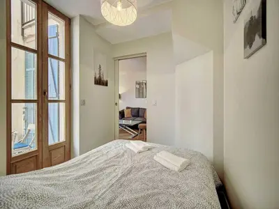 a white bedroom with a bed and a window at Charming apartment, Suquet Cannes - Mobility lease in Cannes