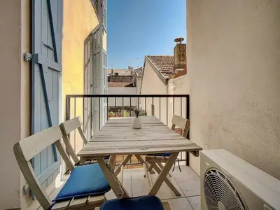 a wooden table and chairs on a balcony at Charming apartment, Suquet Cannes - Mobility lease in Cannes