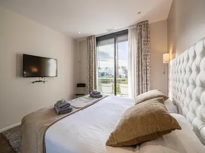 a bedroom with a large bed with a large window at Appt Exclusif - 4BR 8P- Parking - Croisette in Cannes