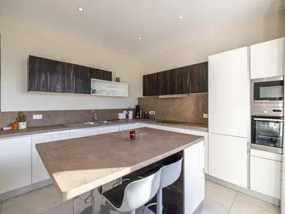 a kitchen with white cabinets and a marble counter top at Appt Exclusif - 4BR 8P- Parking - Croisette in Cannes