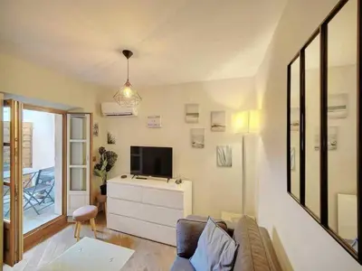 a living room with a couch and a tv at Cosy flat in Cannes - Mobility lease in Cannes