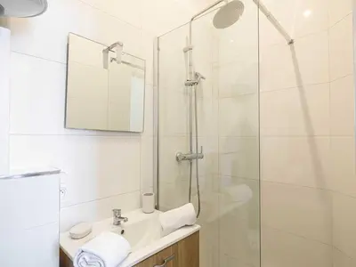 a white bathroom with a shower and a sink at Magnificent studio Cannes center - Mobility lease in Cannes