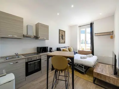 a kitchen with a counter and a table in a room at Magnificent studio Cannes center - Mobility lease in Cannes