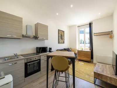 a kitchen with a table and chairs in a room at Magnificent studio Cannes center - Mobility lease in Cannes
