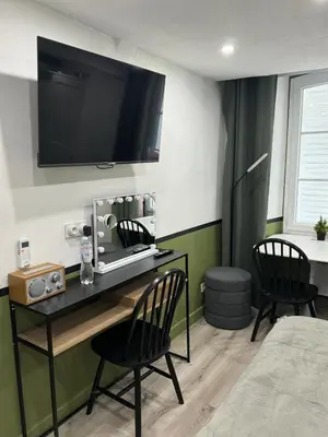 a room with a desk with two chairs and a television on the wall at Studio - Suquet Forville in Cannes