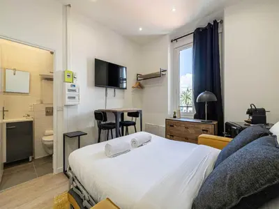 a hotel room with a bed and a bathroom at Gorgeous studio - Cannes center - Mobility Lease in Cannes