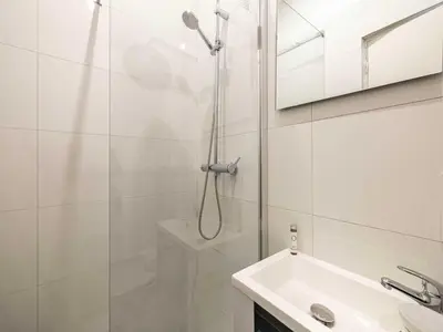 a white bathroom with a shower and a sink at Gorgeous studio - Cannes center - Mobility Lease in Cannes