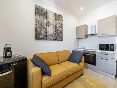 a living room with a yellow couch in a kitchen at Gorgeous studio - Cannes center - Mobility Lease in Cannes