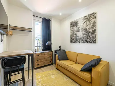 a living room with a couch and a table at Gorgeous studio - Cannes center - Mobility Lease in Cannes