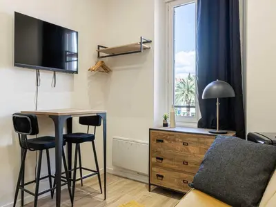 a living room with a desk and a bed and a window at Gorgeous studio - Cannes center - Mobility Lease in Cannes