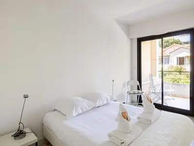 a white bedroom with a bed with towels on it at Charming apt with balcony pool - 1BD 2P - Cannes in Cannes