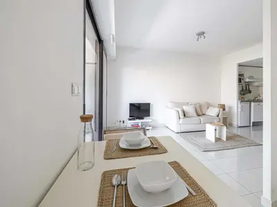 a white living room with a couch and a table at Charming apt with balcony pool - 1BD 2P - Cannes in Cannes