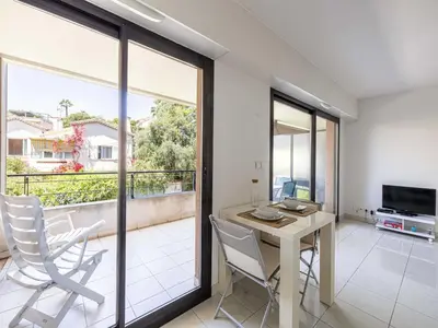 a dining room with a table and chairs and a balcony at Charming apt with balcony pool - 1BD 2P - Cannes in Cannes