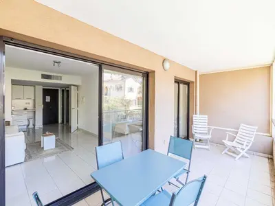 a patio with a table and chairs and a kitchen at Charming apt with balcony pool - 1BD 2P - Cannes in Cannes