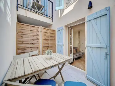 a wooden table and chairs in a room with doors at Lovely renovated apart Terrace - Mobility lease in Cannes