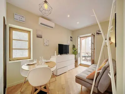 a living room with a table and a swing at Lovely renovated apart Terrace - Mobility lease in Cannes